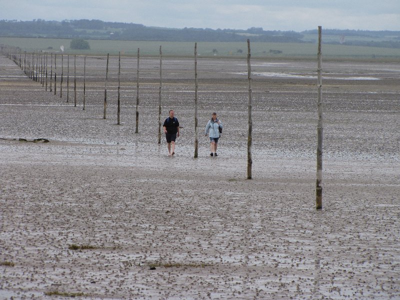 holy island_pilgrims path.jpg - The pilgrims path vanaf Lindisfarne gefotografeerd. Door de telelens lijken de stokken vlak bij elkaar te staan, er zit echter een flinke ruimte tussen.